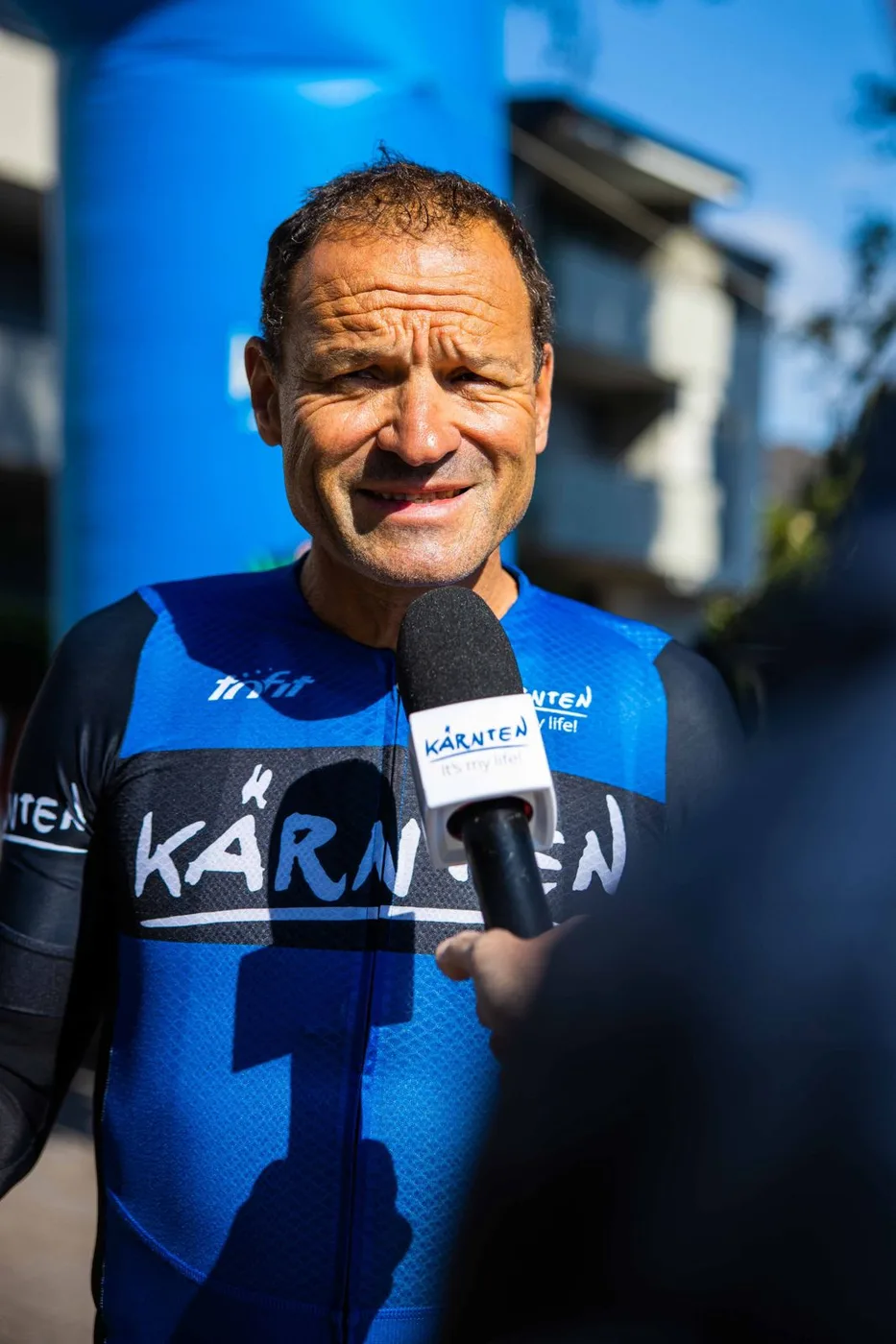 Paco Wrolich im Kärnten-Radtrikot bei einem Interview